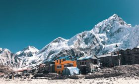 orange and gray houses near snow covered mountain